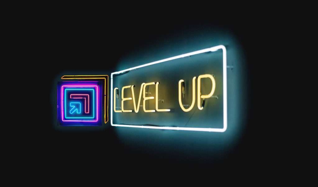 A neon sign with the fulcrum icon and the term Level Up